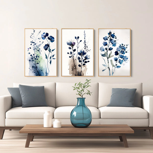 Three framed vertical watercolor floral art prints in shades of blue and beige.