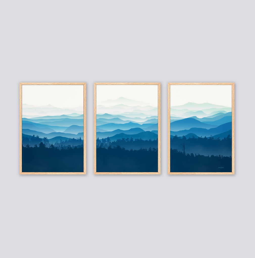 Framed set of 3 landscape canvas art prints in shades of blue. 