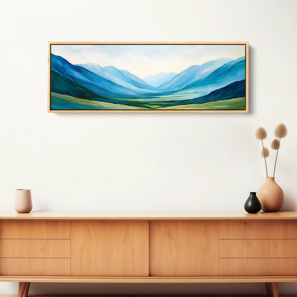 A large mountain valley art print features layered greens and blues.