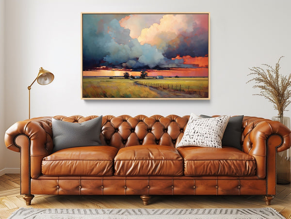 A large rural landscape art print featuring clouds over countryside.